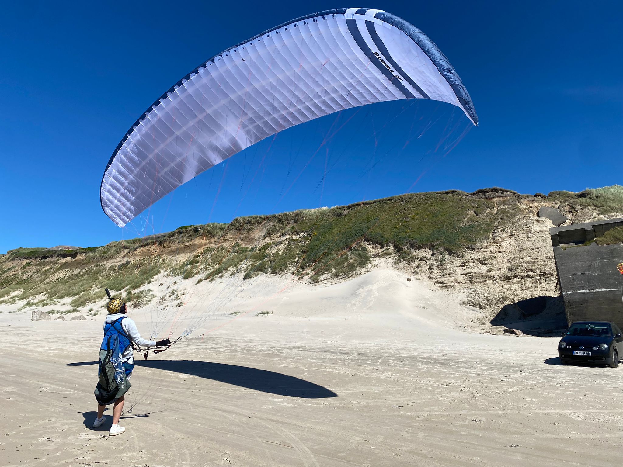 Pilot mit weißer SUPRA am Strand